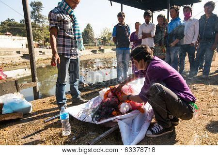 KATHMANDU, NEPAL - DEC 3, 2013: Unidentified local people during the cremation ceremony along the holy Bagmati River in Bhasmeshvar Ghat at Pashupatinath temple in Kathmandu.