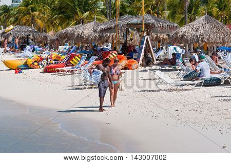 Palm Beach Aruba - December 1 2011: People walking and chatting on the well known Palm Beach in Aruba.