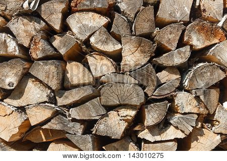 Woodpile texture of birch wood. Background of rustic style. Chopped cordwood stacked and ready for winter.