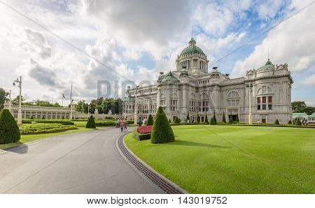 Bangkok Thailand - July 1 2016: Ananta Samakhom Throne Hall having tourists walking on the path near green lawn with cloudy blue sky as background
