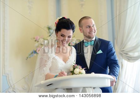 Beauty Bride And Handsome Groom Are Registering The Marriage. Wedding Couple Is Marrying. Beautiful