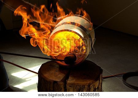 Flaming whiskey barrel getting prepped for distillation