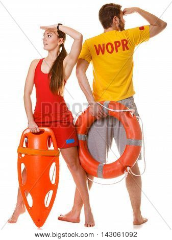 Lifeguards with rescue tube and ring buoy lifebuoy. Man and woman supervising swimming pool looking out into the distance. Accident prevention.
