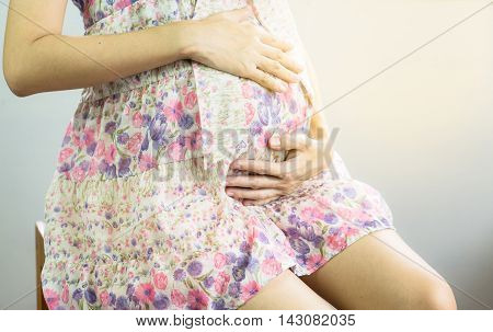 asian pregnant woman touching her belly with hands
