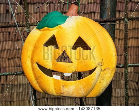 Autumn halloween pumpkin hanging on the fence. Holiday symbol. All Saints' Eve.
