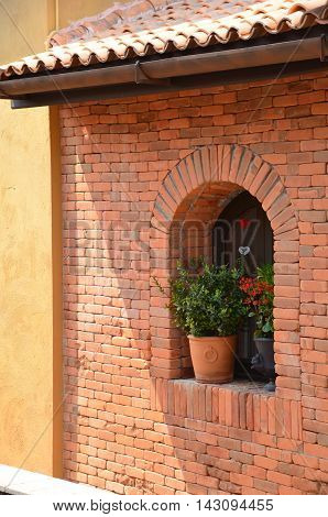 Shady brick facade with a pot of plant