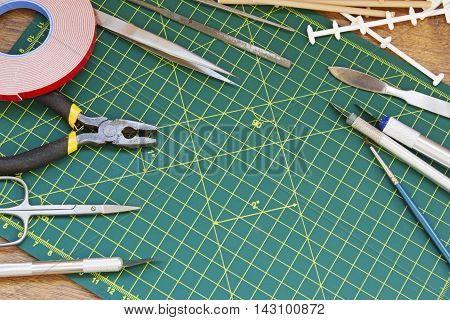 Plastic model kit and tools hobby workplace background top view.