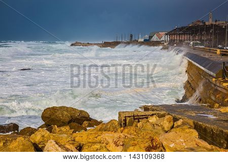 Whole gale in the Mediterranean Sea. Huge foamy waves fight about the coast. New Quay in the Old Jaffa, Israel