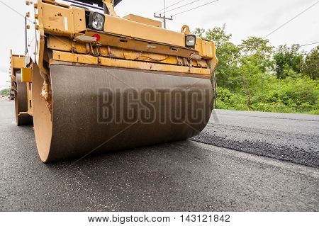 Road construction works with roller compactor machine and asphalt finisher