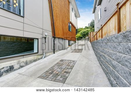Luxury Driveway To Garage Near Modern House With Wooden Pannel Trim.