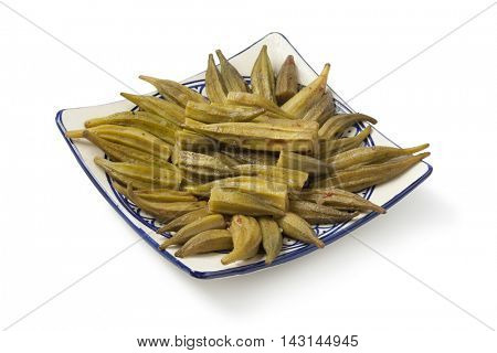 Moroccan green okra salad on a dish on white background