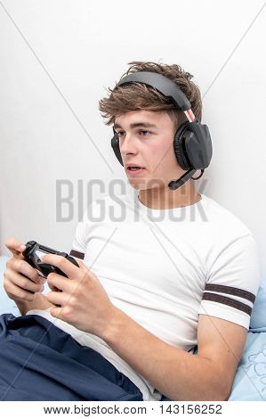 Teenage boy concentraing on playing a video game