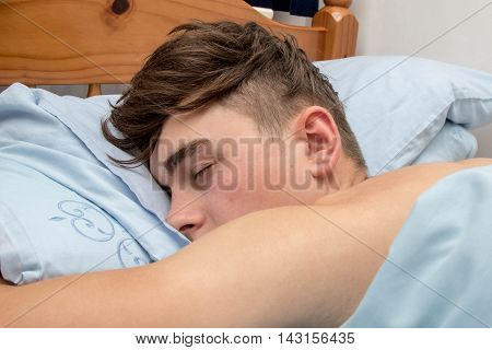 Teenage boy fast alseep in his bed