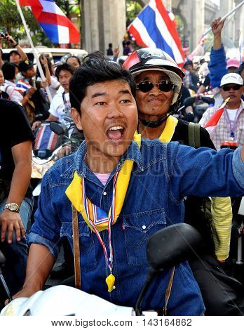 Bangkok Thailand - January 13 2014: Exuberant Thai man riding on a motorcycle during the anti-government Operation Shut Down Bangkok protests