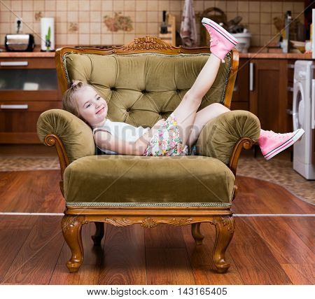 Little girl shows pink sneakers on chair