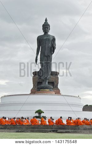 Nakhon Pathom, Thailand - August 4, 2016: Buddhist Monks Praying In Front Of Walking Buddha Statue A