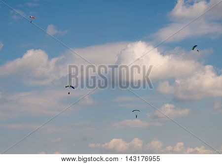 skydivers against the blue sky with white clouds