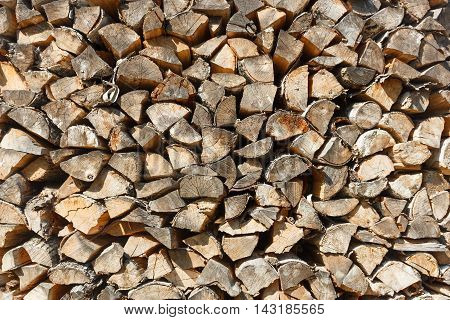 Woodpile texture of birch wood. Background of rustic style. Chopped cordwood stacked and ready for winter.