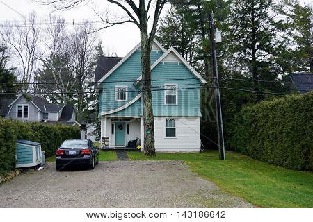 WEQUETONSING, MICHIGAN / UNITED STATES - DECEMBER 22, 2015: A light blue and white home on Pennsylvania Avenue in Wequetonsing, Michigan.
