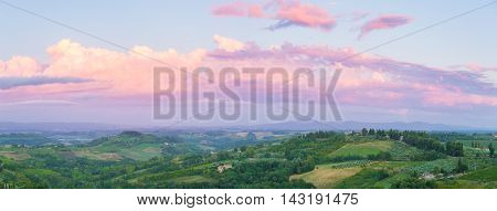 Wide panoramic landscape at twilight of surroundings of the medieval city of San Giminiano Tuscany Italy.