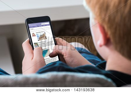 Close-up Of A Boy Using Social Networking Site On Mobile Phone