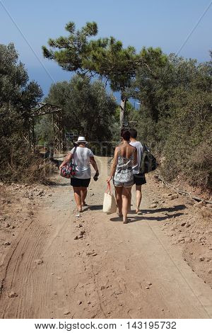 28TH JULY 2016, KABAK, TURKEY: Tourists walking along a dirt road at Kabak in Turkey, 28th july 2016