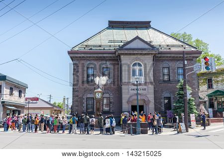 Otaru Hokkaido Japan- June 5 2016. Tourists visited the vintage steam clock tower in front of Otaru Music Box Museum. The steam clock was made by Canadian clock maker Raymond Sounders in 1977.