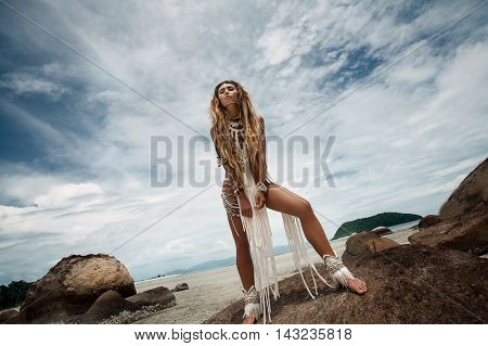 Attractive wild boho woman at beach. Native american style