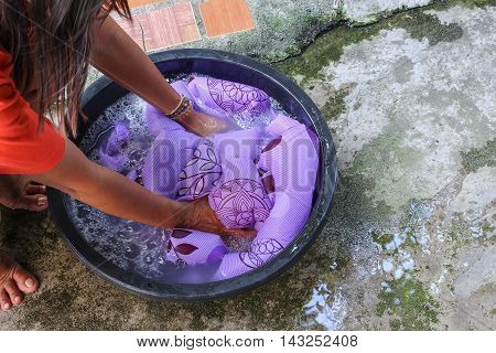 Woman wash hands dirty clothes in the basin black for cleansing Thailand washing clothes style ancient