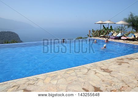 29TH JULY 2016, KABAK, TURKEY : English tourists having a swim and cooling off in an infinity pool at Kabak in Turkey, 29th july 2016
