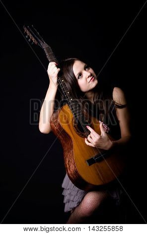Girl with a guitar on a black background