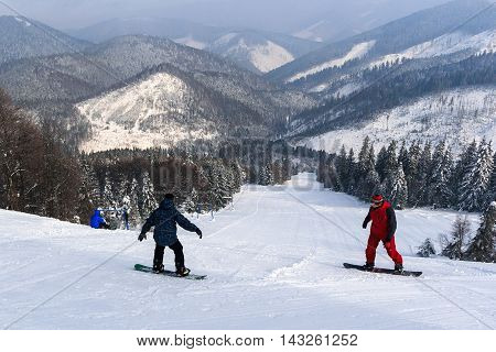 Snowboarders, descent from the mountain. Tysovets Carpathians Ukraine
