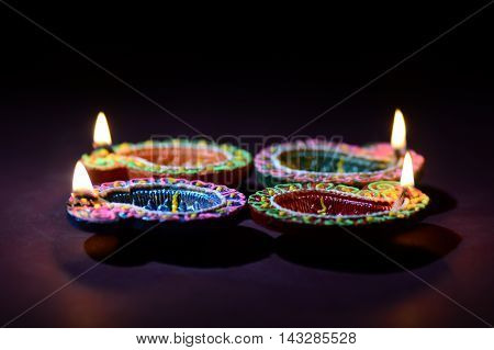 Colorful clay Diya (Lantern) lamps lit during Diwali celebration. Greetings Card Design Indian Hindu Light Festival called Diwali.