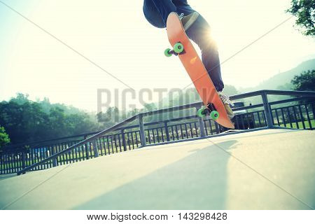 one young skateboarder skateboarding at sunrise skatepark