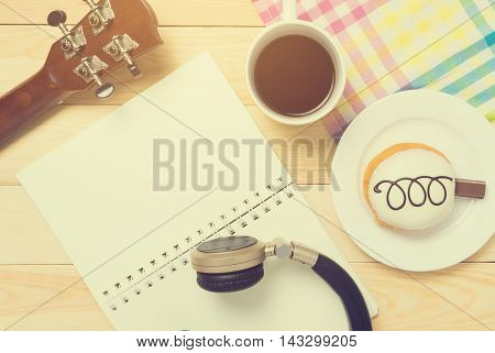 Music writing chilling relax top view equipments. Guitar Blank note book Music headphone and Coffee for Music writing concept background.