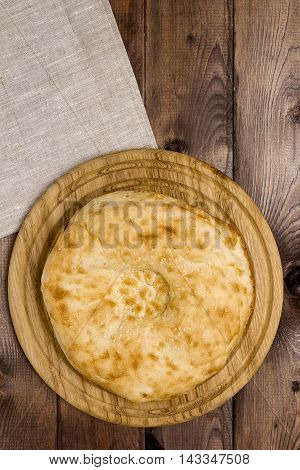 Traditional Uzbek bread on a plate on a wooden background