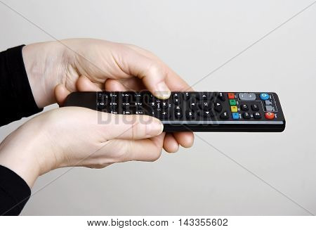 Hands mature asian woman and control panel TV