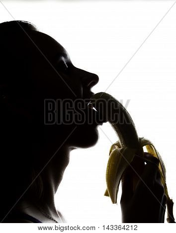Young amazed woman in lacy lingerie holding a banana, she is going to eat a banana. she sucks a banana.