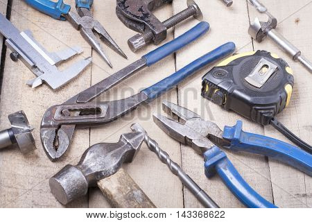 Construction tools on wooden background. Copy space for text. Set of assorted work tools at wood table . Top view.