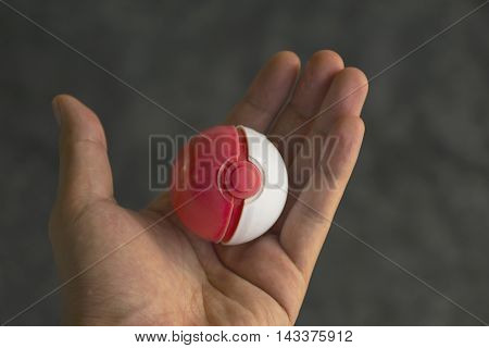 Thailand - August 20, 2016: Poke ball in Hand  (Pokemon Ball). Pokeball toy of the game Pokemon Go at Chon Buri, Thailand.