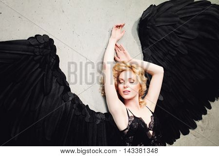 Sexy Woman with Angel Wings Relaxing on the Floor