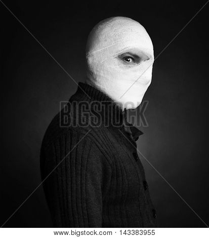 Head tied up by bandage in a grey background