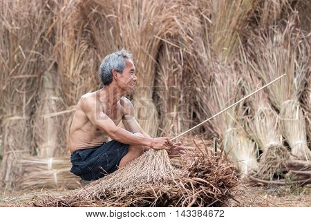 Old man makes wicker work baskets using material from the bamboo.
