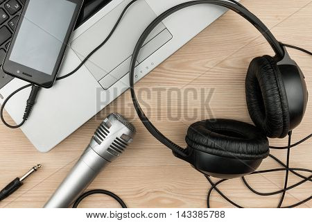 Laptop microphone headsets lies on a wooden table background top view