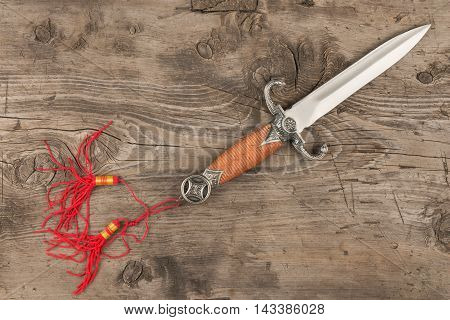Dagger lying on a wooden surface top view