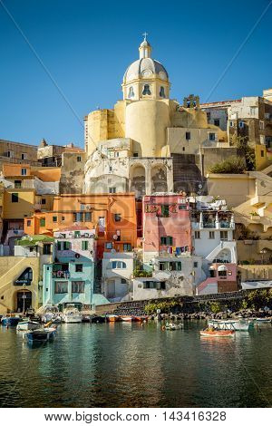 Colorful houses and an old church in Corricella village on Procida island in Italy