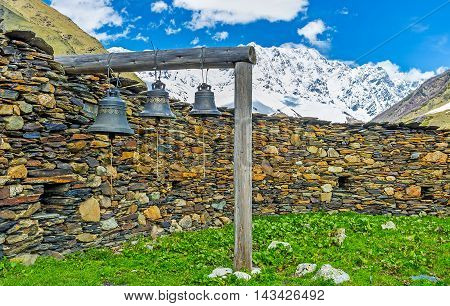 The old bells of Lamaria church next to the huge stone fence Ushguli Georgia.