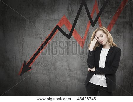 Business woman standing near blackboard with arrows going down. Concept of decline and economical crisis.