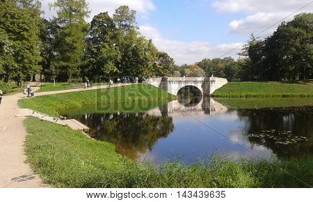 old arched stone bridge across the pond