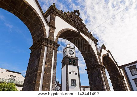 The historical entrance (Portas da Cidade) to the village of Ponta Delgada in Azores Portugal. Entrance gates and the clock tower of Saint Sabastian church.